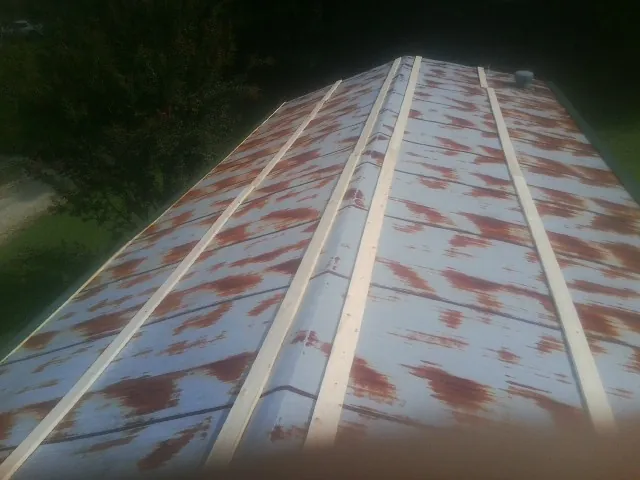 Rusted metal roof panels with new wood purlins before replacement — Storm Damage Roof Repair in Saltsburg by Roofing Brothers