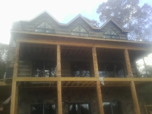 Dormers and porch framing on a large log home under construction — Roof Coating work by our crew in Saltsburg