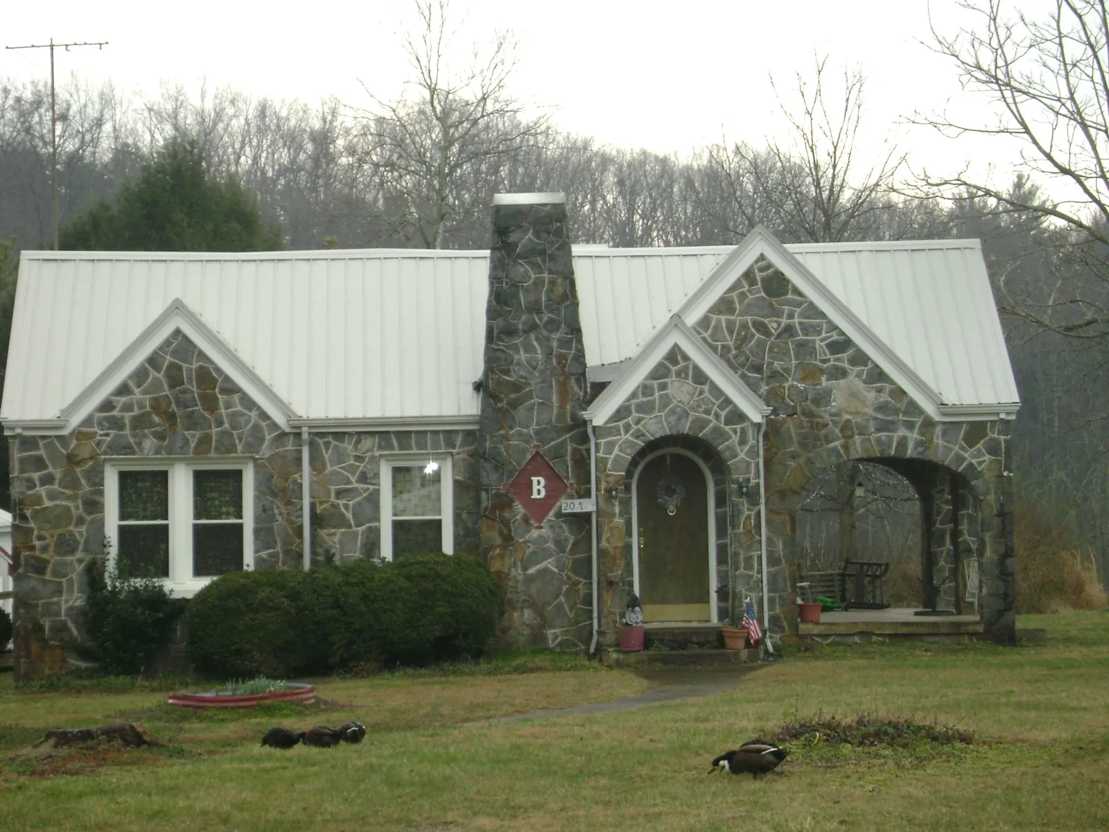 White metal roof on a stone cottage with steep gables in Saltsburg